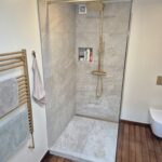 Badeværelse renoveret i København med store fliser og bruseniche