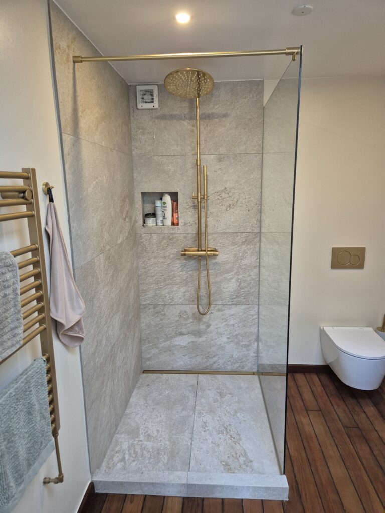 Badeværelse renoveret i København med store fliser og bruseniche